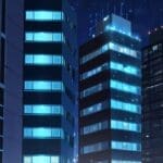 Edificios modernos y tecnológicos con luces urbanas en la noche, reflejando innovación y ciencia.