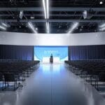 Centro de conferencias moderno con asistentes y tecnología avanzada en exhibición.