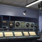 Interior de una moderna estación de radio con micrófonos y equipos tecnológicos.