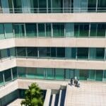 Vista aérea de un moderno edificio de oficinas tecnológicas rodeado de áreas verdes.