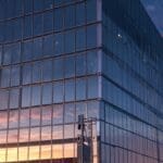 Edificio de oficinas tecnológicas modernas iluminado al atardecer, reflejando un enfoque corporativo y tecnológico