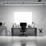 Oficina moderna con escritorios minimalistas y una laptop abierta mostrando gráficos financieros en pantalla