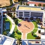 Vista aérea de un centro de conferencias moderno en Marbella rodeado de palmeras y edificios contemporáneos