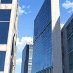 Edificios modernos rodeados por vegetación y paneles solares bajo un cielo despejado