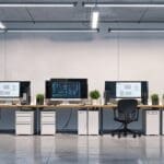 Oficina moderna con computadoras portátiles y pizarras electrónicas.