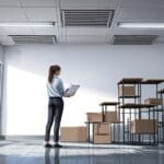 Oficina moderna con pantallas mostrando una plataforma de mensajería para trámites laborales