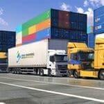 Moderno centro logístico con camiones y contenedores en actividad durante el día.