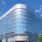 Edificio moderno de oficinas en un distrito tecnológico, con cielo despejado y luz diurna