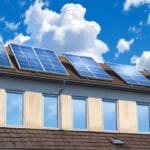 Instalación de paneles solares en techos de casas modernas bajo un cielo despejado