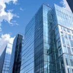 Edificios modernos de oficinas conectados por tecnología con un cielo despejado