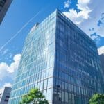 Edificio moderno de oficinas en un distrito financiero urbano con cielo despejado.