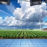 Campo agrícola con sistema tecnológico de monitoreo bajo cielo despejado.