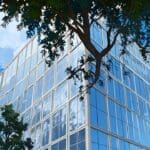 Edificio gubernamental moderno rodeado de árboles y cielo despejado