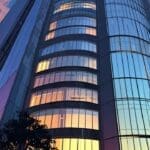 Vista de un moderno edificio corporativo en un parque tecnológico al atardecer.