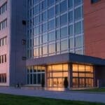 Edificio universitario moderno al atardecer con un entorno tecnológico