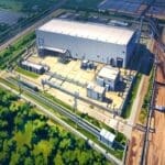 Vista aérea de una moderna planta industrial rodeada de vegetación en un entorno urbano