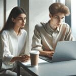 Dos jóvenes emprendedores trabajando en una laptop en un coworking moderno