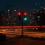 Semáforo con luz blanca innovadora en ciudad inteligente optimizando movilidad urbana y vehículos autónomos.