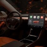 Tablero de Tesla con interfaz CarPlay iluminada representando tendencias en movilidad eléctrica e innovación automotriz.