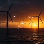 Parque eólico offshore en el Reino Unido con turbinas girando al atardecer, simbolizando récords y oportunidades tecnológicas en energía eólica offshore.